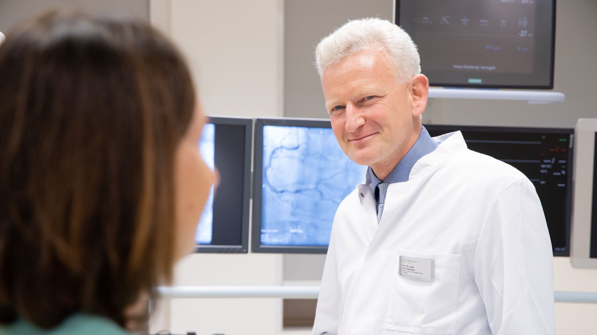 Dr. Jan Torzewski im GEspräch mit einer OP-Fachkraft im Operationssaal im Herz- & Gefäßzentrum am Standort Kempten