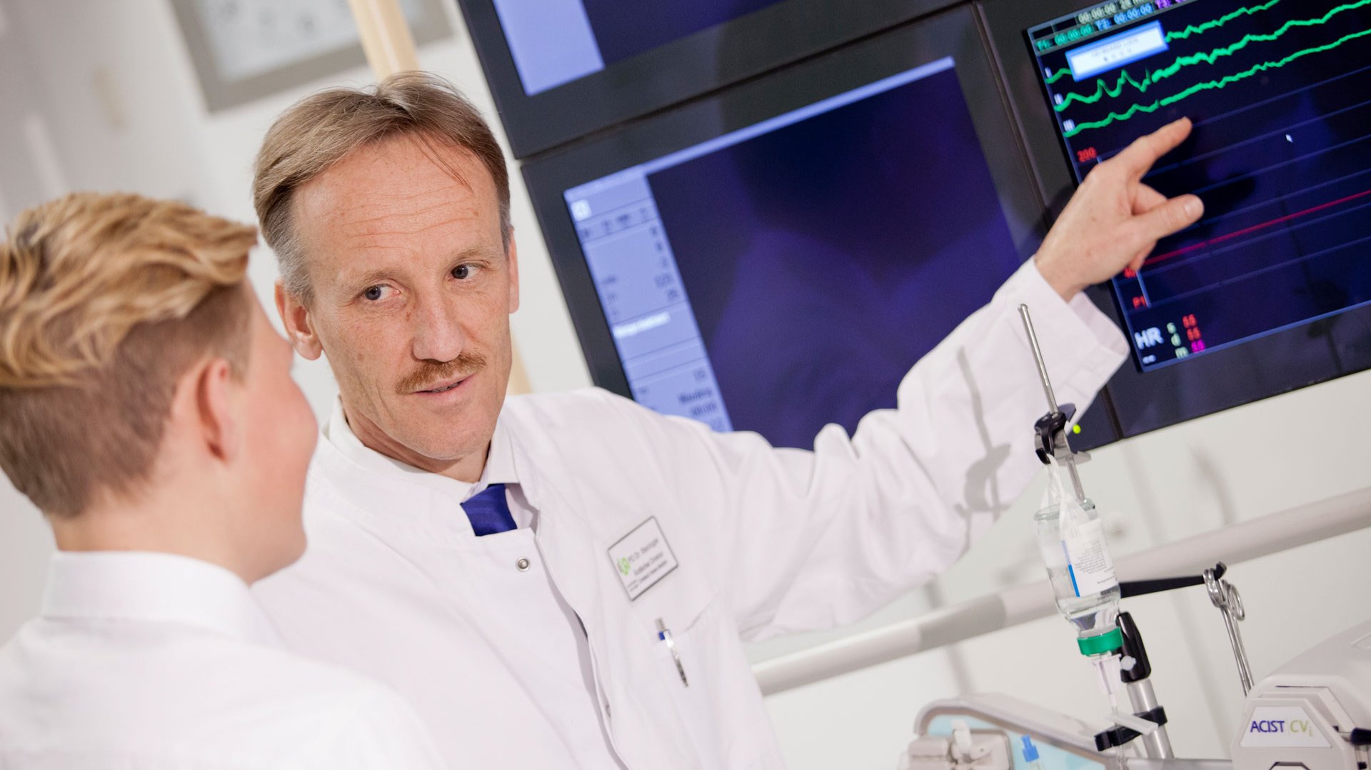 Chefarzt Dr. Peter Steinbigler bespricht mit einem Kollegen Ergebnisse an einem Monitor